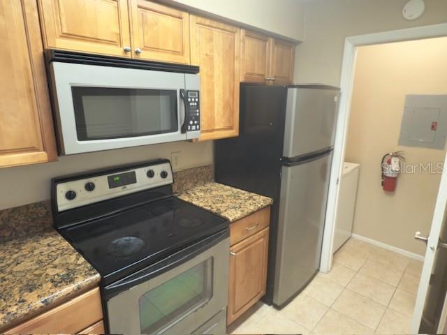 208 Afton Sq Unit 307, Altamonte Springs, FL 32714 - kitchen with appliances with stainless steel finishes, electric panel, light tile patterned floors, stone counters, and baseboards