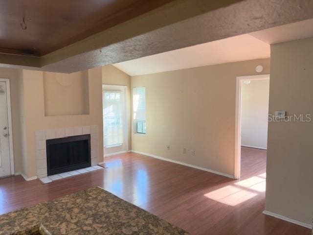 208 Afton Sq Unit 307, Altamonte Springs, FL 32714 - unfurnished living room with wood finished floors, a tiled fireplace, and baseboards