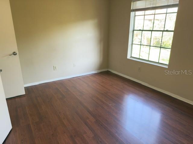 208 Afton Sq Unit 307, Altamonte Springs, FL 32714 - unfurnished room featuring baseboards and wood finished floors