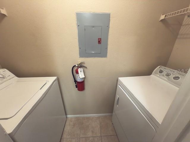 208 Afton Sq Unit 307, Altamonte Springs, FL 32714 - laundry area featuring electric panel, separate washer and dryer, light tile patterned flooring, and baseboards