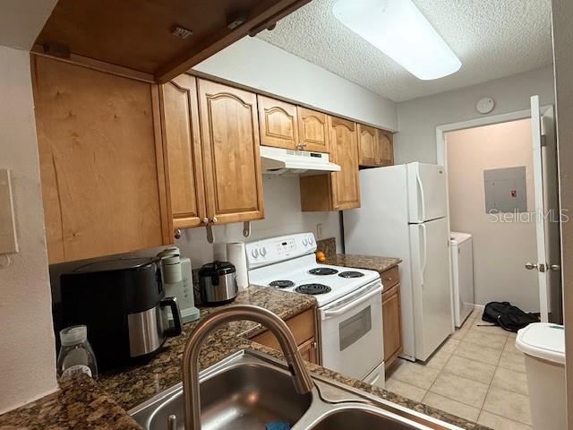 224 Afton Sq Unit 301, Altamonte Springs, FL 32714 - kitchen featuring white appliances, under cabinet range hood, a textured ceiling, light tile patterned floors, and a sink
