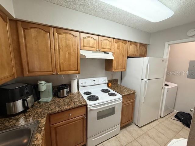 224 Afton Sq Unit 301, Altamonte Springs, FL 32714 - kitchen with white appliances, under cabinet range hood, brown cabinets, a textured ceiling, and independent washer and dryer