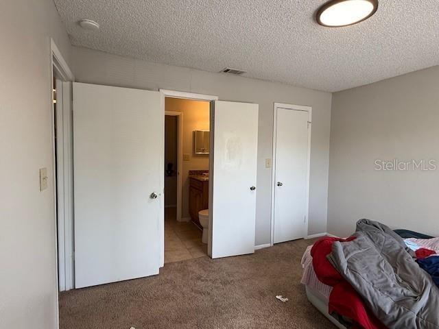 224 Afton Sq Unit 301, Altamonte Springs, FL 32714 - carpeted bedroom with a textured ceiling and ensuite bathroom