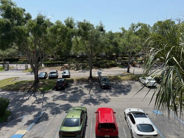 224 Afton Sq Unit 301, Altamonte Springs, FL 32714 - view of asphalt road featuring curbs and view of wooded area