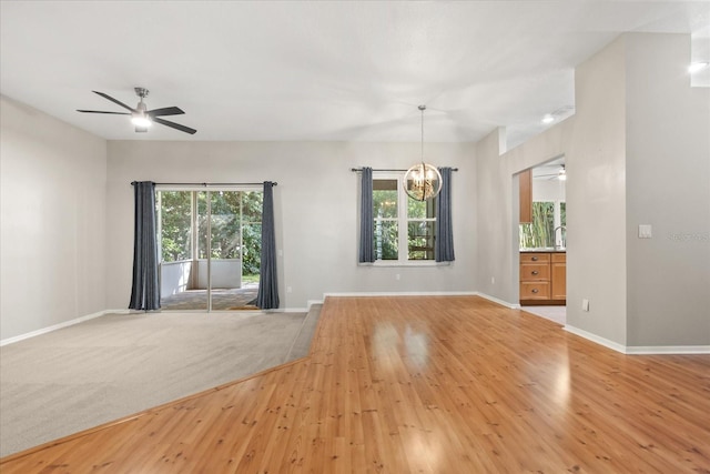 14841 Faversham Cir, Orlando, FL 32826 - spare room with baseboards, a chandelier, ceiling fan, and light wood-type flooring