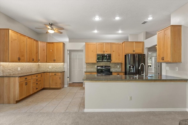 14841 Faversham Cir, Orlando, FL 32826 - kitchen with electric range oven, black refrigerator with ice dispenser, stainless steel microwave, a ceiling fan, and a peninsula