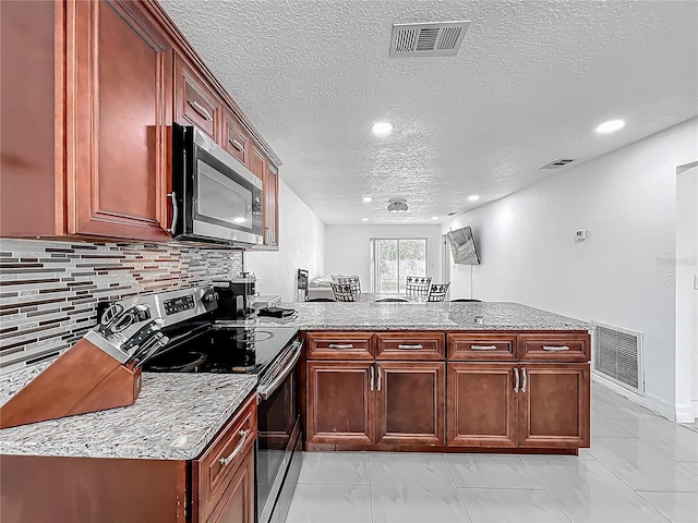 kitchen with marble finish floor, visible vents, a peninsula, a textured ceiling, and appliances with stainless steel finishes