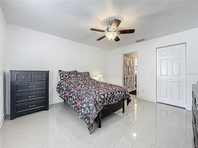 bedroom featuring a textured ceiling, visible vents, marble finish floor, and baseboards