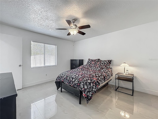 bedroom featuring baseboards, a ceiling fan, and a textured ceiling