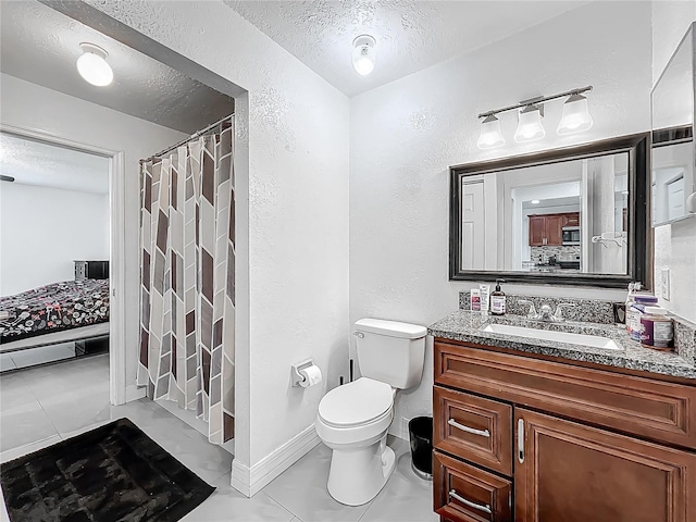 ensuite bathroom featuring a textured ceiling, a textured wall, and ensuite bathroom
