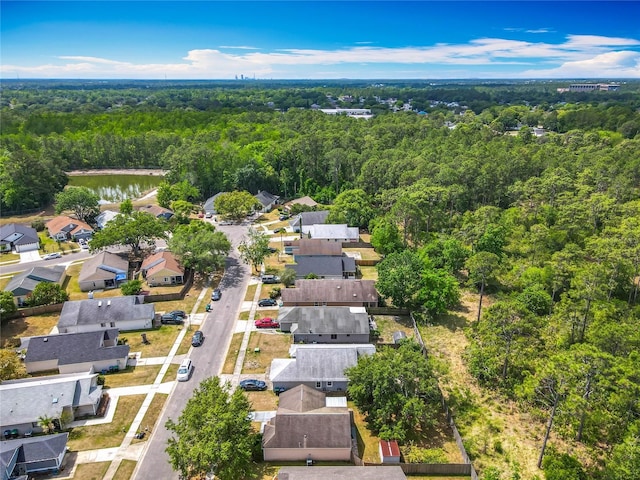 drone / aerial view featuring a residential view and a forest view