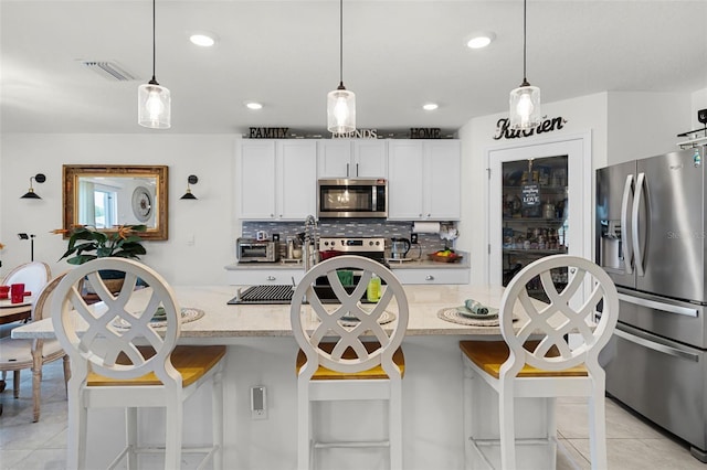 1220 Tahitian Sunrise Dr, Plant City, FL 33565 - kitchen featuring light tile patterned floors, visible vents, appliances with stainless steel finishes, and decorative backsplash