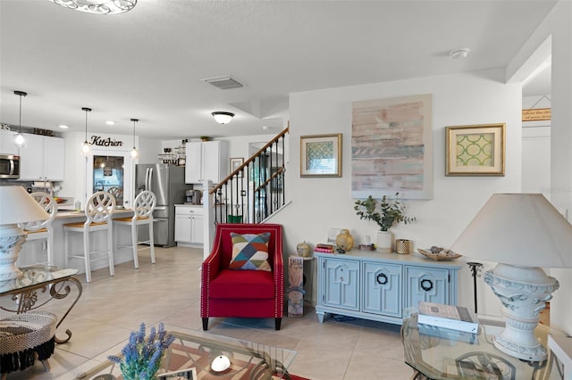 1220 Tahitian Sunrise Dr, Plant City, FL 33565 - living area featuring light tile patterned floors, visible vents, and stairs