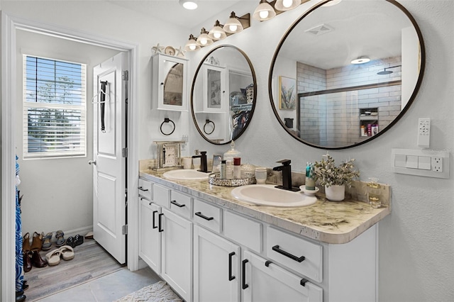 1220 Tahitian Sunrise Dr, Plant City, FL 33565 - bathroom with double vanity, visible vents, a stall shower, and a sink