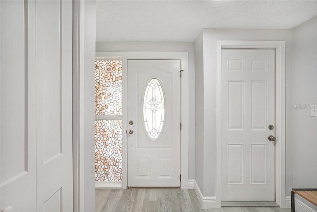 4043 Topsail Trl, New Port Richey, FL 34652 - entrance foyer with baseboards, a textured ceiling, and light wood-style flooring
