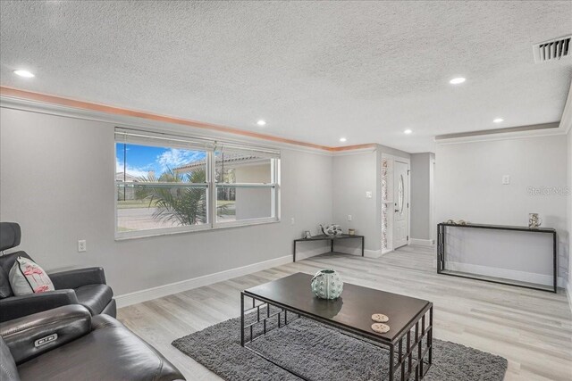 4043 Topsail Trl, New Port Richey, FL 34652 - living room with visible vents, ornamental molding, and a textured ceiling