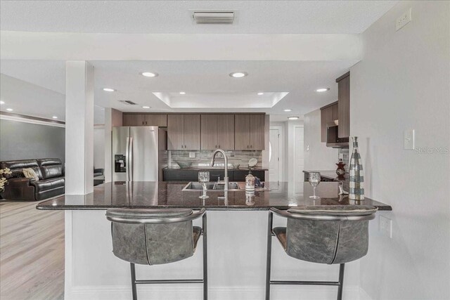 4043 Topsail Trl, New Port Richey, FL 34652 - kitchen with a sink, a raised ceiling, a peninsula, stainless steel refrigerator with ice dispenser, and visible vents