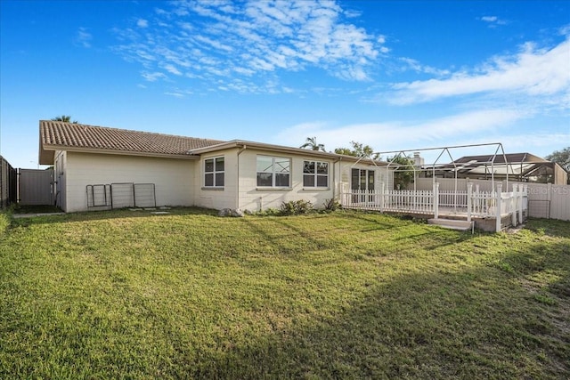 4043 Topsail Trl, New Port Richey, FL 34652 - rear view of property featuring a fenced backyard, a gate, a tiled roof, and a lawn