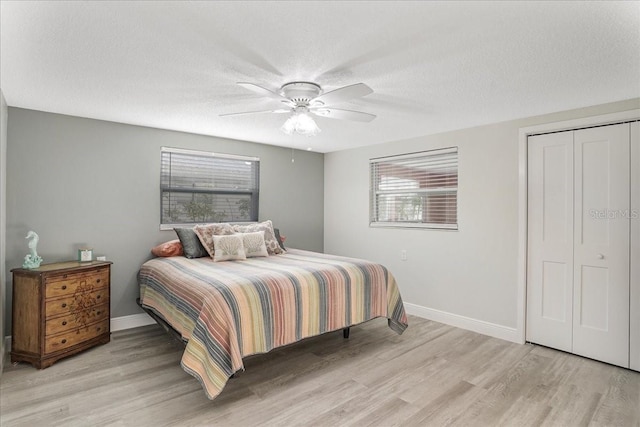 4043 Topsail Trl, New Port Richey, FL 34652 - bedroom featuring a ceiling fan, a textured ceiling, baseboards, a closet, and light wood-style flooring