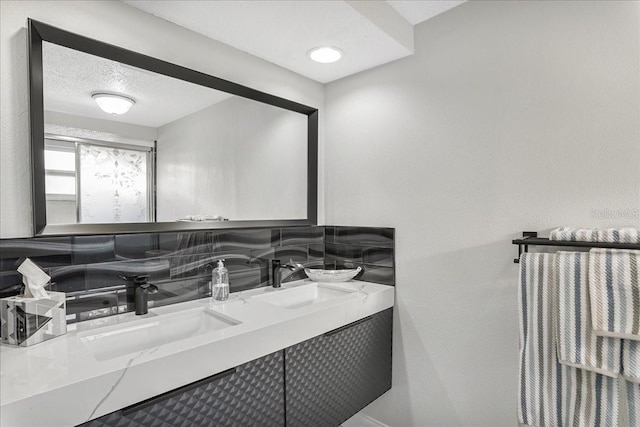 4043 Topsail Trl, New Port Richey, FL 34652 - bathroom featuring a sink, tasteful backsplash, a textured wall, and double vanity