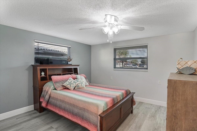 4043 Topsail Trl, New Port Richey, FL 34652 - bedroom with a textured ceiling, baseboards, and light wood finished floors