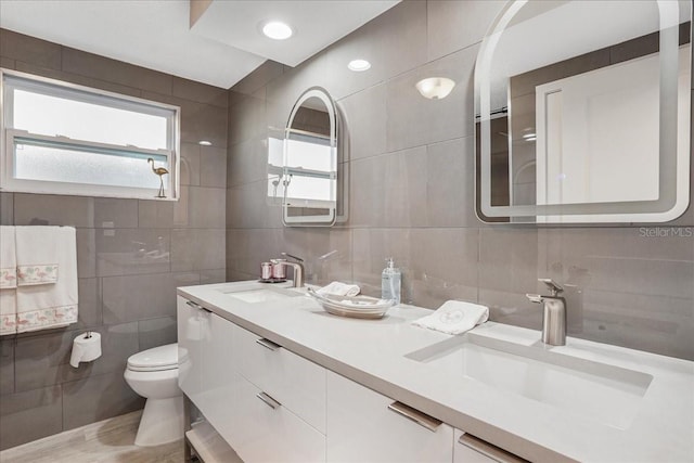 4043 Topsail Trl, New Port Richey, FL 34652 - bathroom featuring a sink, tile walls, tasteful backsplash, and toilet