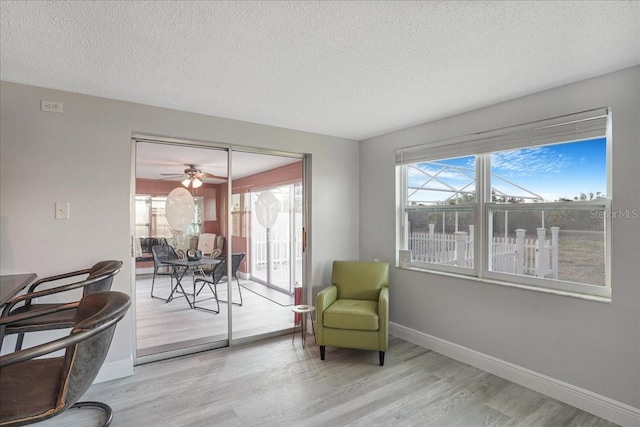 4043 Topsail Trl, New Port Richey, FL 34652 - sitting room with baseboards, a ceiling fan, a textured ceiling, and wood finished floors