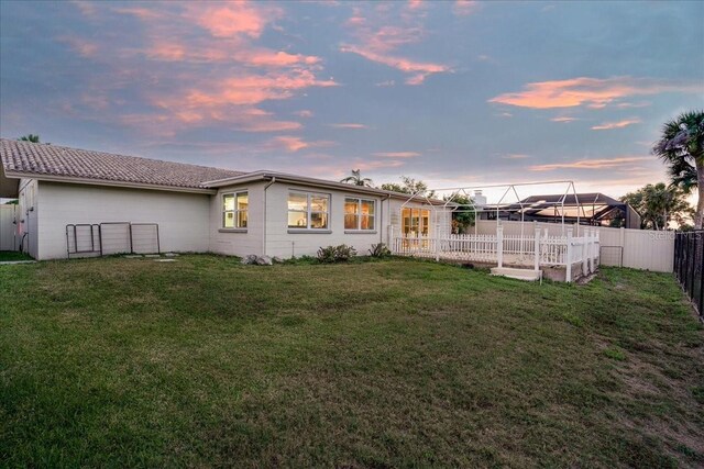 4043 Topsail Trl, New Port Richey, FL 34652 - back of property at dusk featuring a fenced backyard and a yard