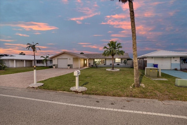 4043 Topsail Trl, New Port Richey, FL 34652 - ranch-style home featuring decorative driveway, a garage, a lawn, and stucco siding