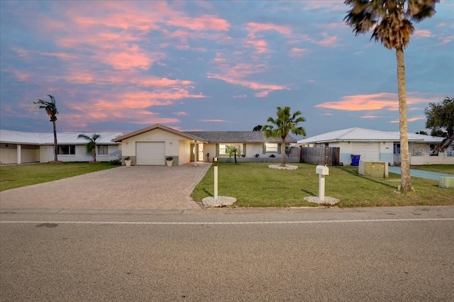 4043 Topsail Trl, New Port Richey, FL 34652 - ranch-style home with fence, a front yard, decorative driveway, stucco siding, and an attached garage