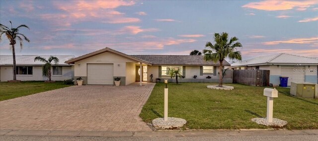 4043 Topsail Trl, New Port Richey, FL 34652 - single story home with a garage, decorative driveway, fence, a front lawn, and stucco siding