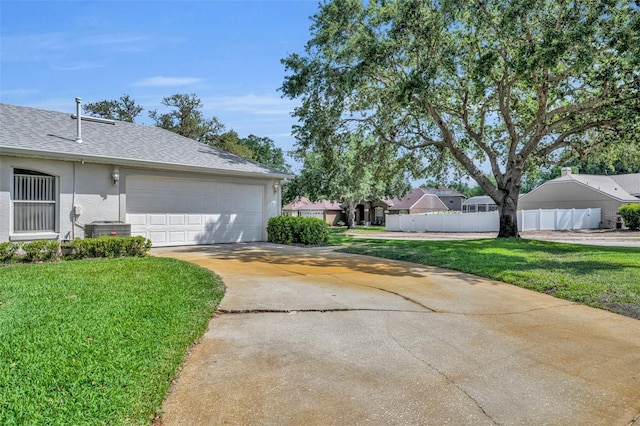 view of home's exterior with central AC, fence, driveway, and a yard