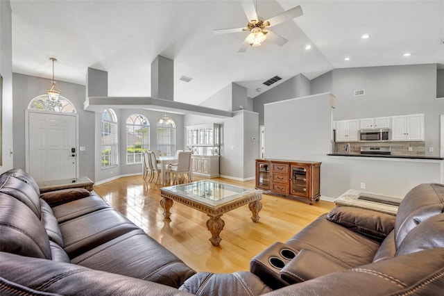 living area with a ceiling fan, visible vents, baseboards, and light wood-style floors
