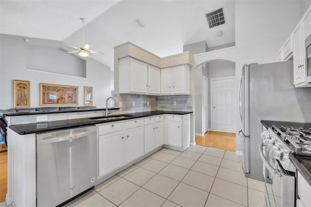 kitchen featuring a sink, a ceiling fan, white cabinetry, arched walkways, and appliances with stainless steel finishes