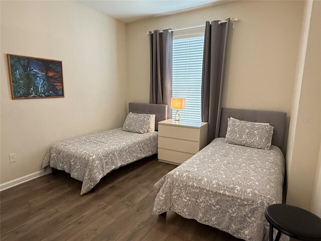bedroom featuring dark wood-type flooring and baseboards