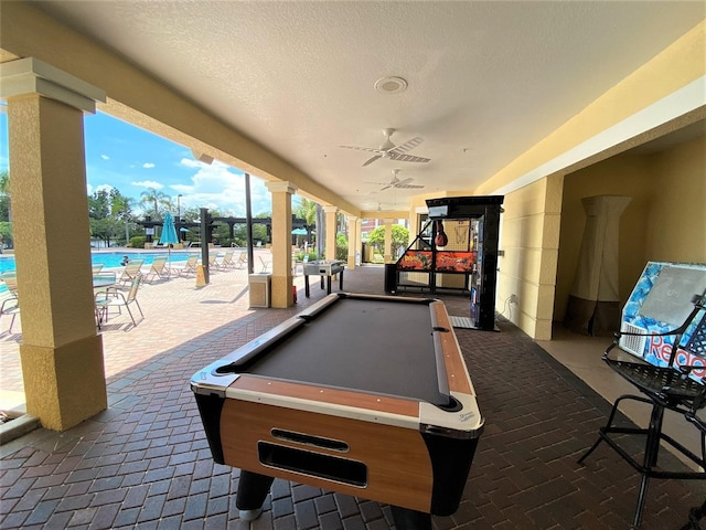 rec room with ornate columns, ceiling fan, billiards, and brick floor
