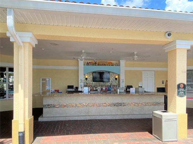 reception area with a ceiling fan and decorative columns