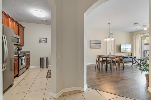 4024 Breakview Dr Unit 40604, Orlando, FL 32819 - kitchen with appliances with stainless steel finishes, arched walkways, brown cabinets, pendant lighting, and ceiling fan