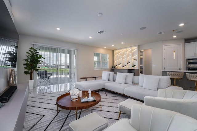 living area featuring visible vents and recessed lighting