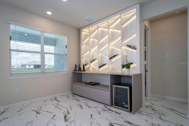 interior space featuring marble finish floor, visible vents, baseboards, and beverage cooler