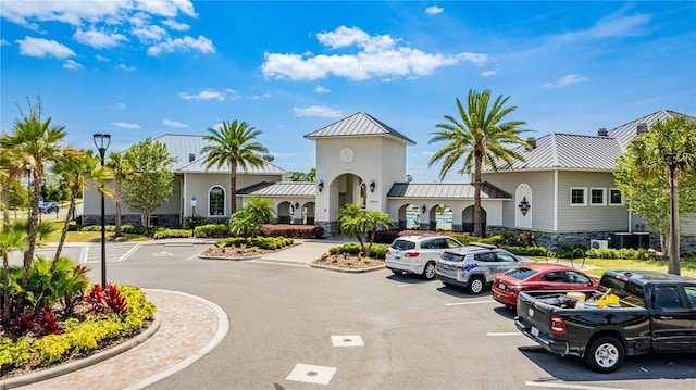 view of property featuring central AC and uncovered parking