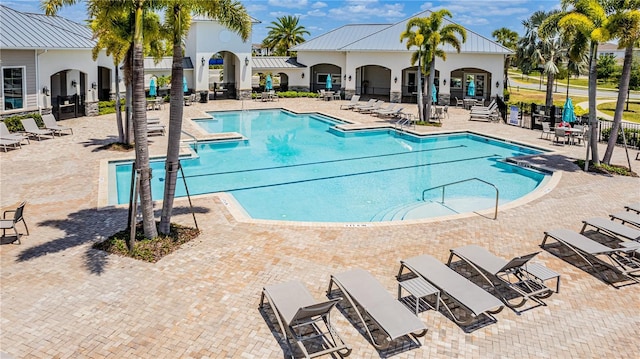 community pool with fence and a patio area