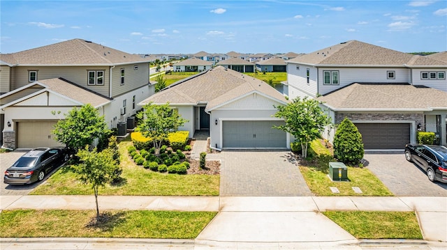 traditional home with a residential view, driveway, a garage, and central air condition unit