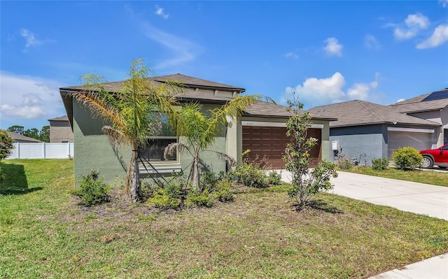 view of front of home featuring a garage, a front lawn, fence, stucco siding, and concrete driveway
