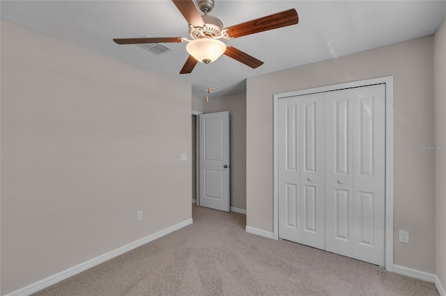 unfurnished bedroom with a closet, visible vents, light carpet, baseboards, and ceiling fan