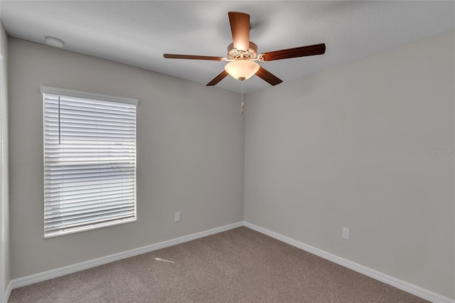 empty room featuring baseboards, carpet flooring, and ceiling fan
