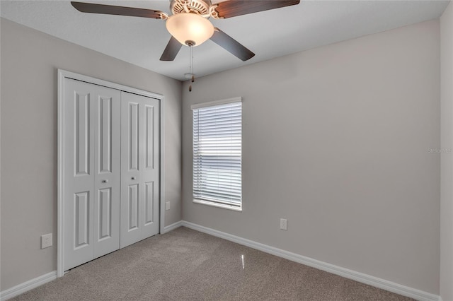 unfurnished bedroom with baseboards, ceiling fan, carpet, and a closet