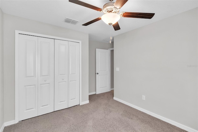 unfurnished bedroom with visible vents, a closet, baseboards, ceiling fan, and carpet flooring