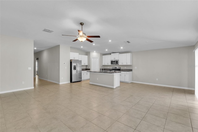 kitchen with visible vents, dark countertops, appliances with stainless steel finishes, a sink, and open floor plan