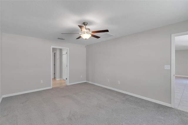 empty room featuring visible vents, a ceiling fan, baseboards, and carpet flooring